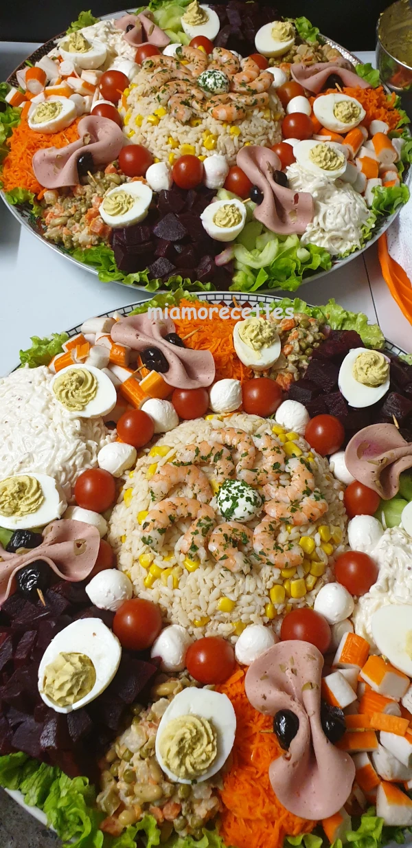 2 assiettes de salade composée à la marocaine décorées avec des crevettes, des tomates cerises et des boules de mozzarella