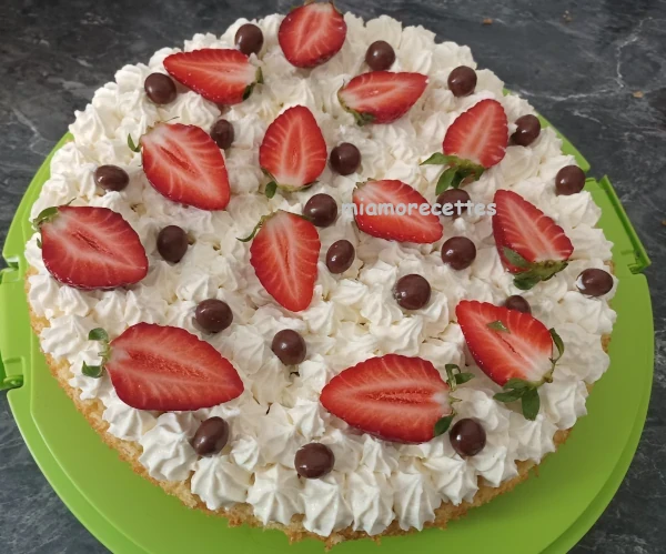 Gâteau à la crème décoré avec des fraises et des billes en chocolat