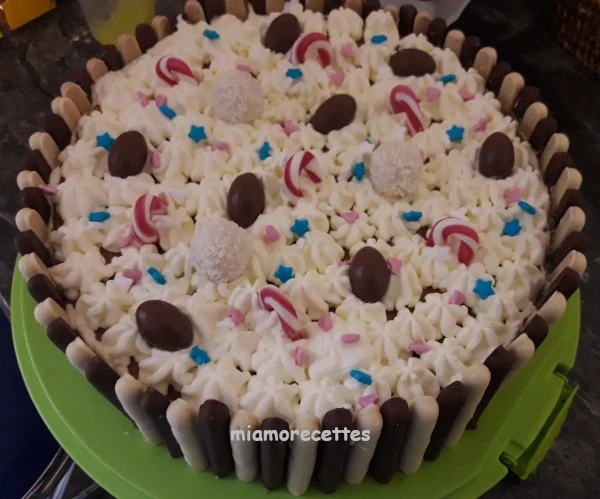 Gâteau à la crème entouré de batônnets de chocolat noir et blanc et décoré avec des bonbons