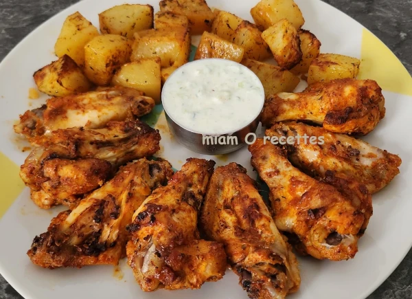 Ailes de poulet et pommes de terre marinées et cuites au four